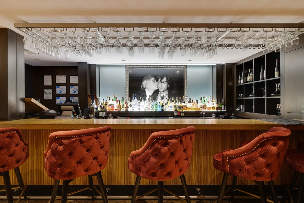 Plush tufted chairs line the wood counter at Bar Louis, one of the most stylish bars in Milford, PA.