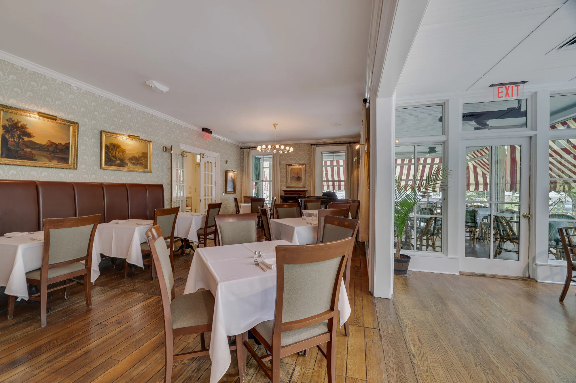 The sophisticated dining room at the Delmonico Room features white linen tables and classic leather banquettes.