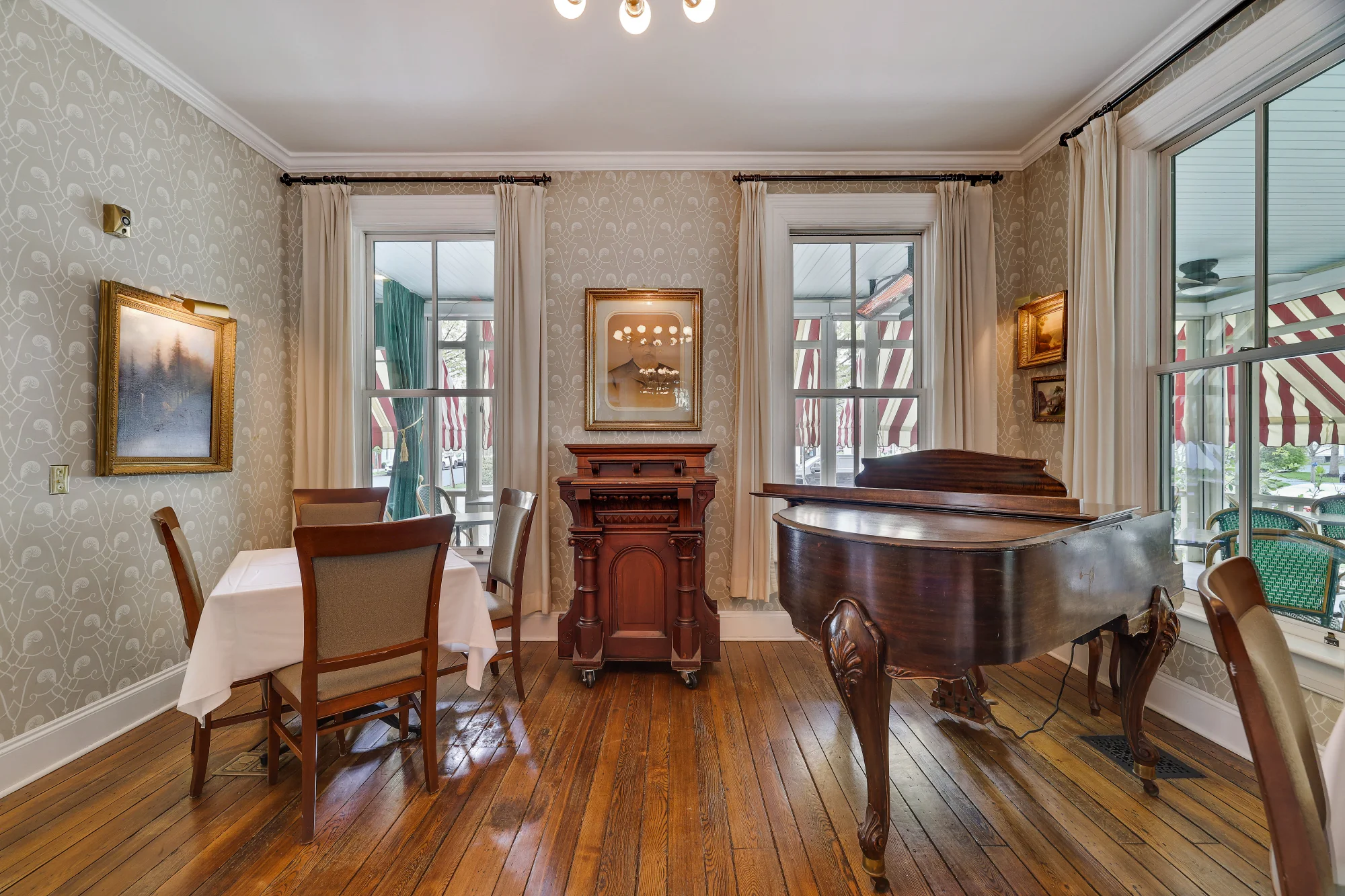 The Delmonico Room features elegant table settings and a grand piano for a refined dining experience in Milford, PA.
