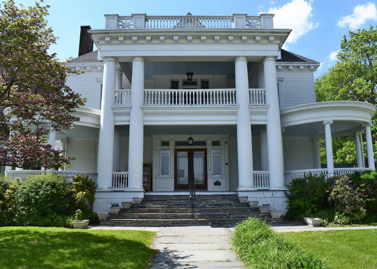 The grand white exterior and columns of Hotel Fauchère, a historic place to stay in Milford, Pennsylvania.