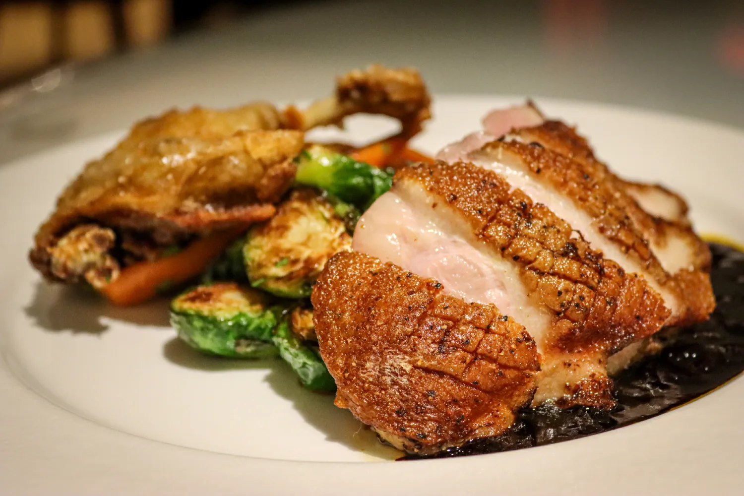 Sliced roasted duck breast and crispy confit leg with brussels sprouts served at the Delmonico Room in Milford, PA.