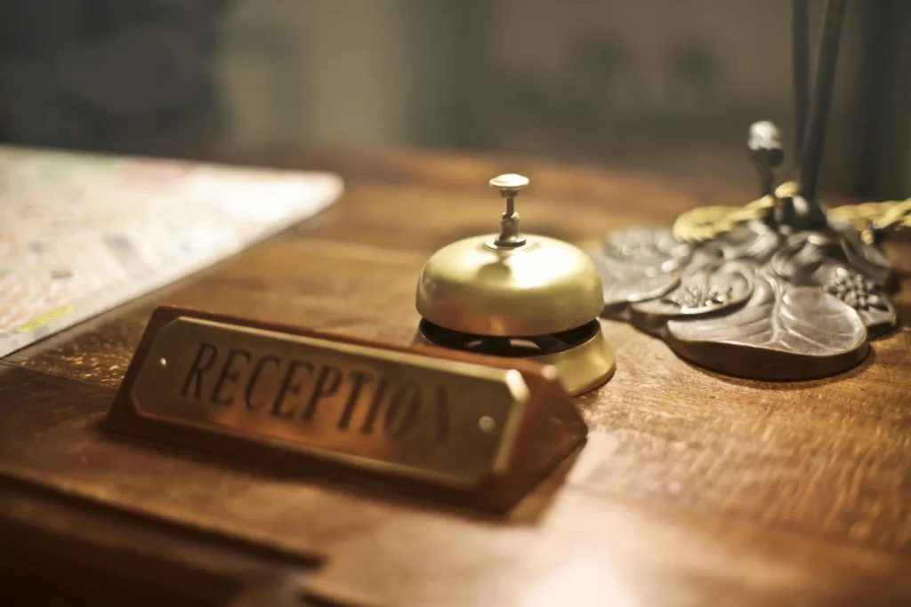 A vintage brass call bell sits on the wooden reception desk at a historic hotel in Milford, PA.