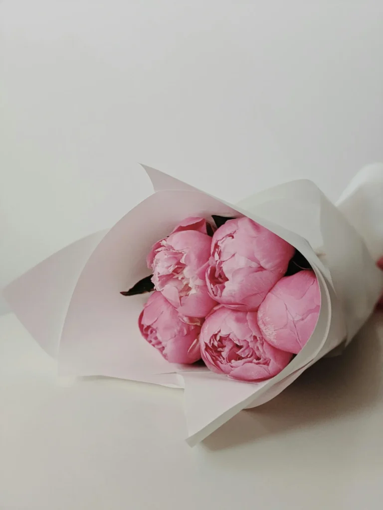 Lush pink peonies wrapped in white paper, ideal for celebrations at our Milford wedding venue.