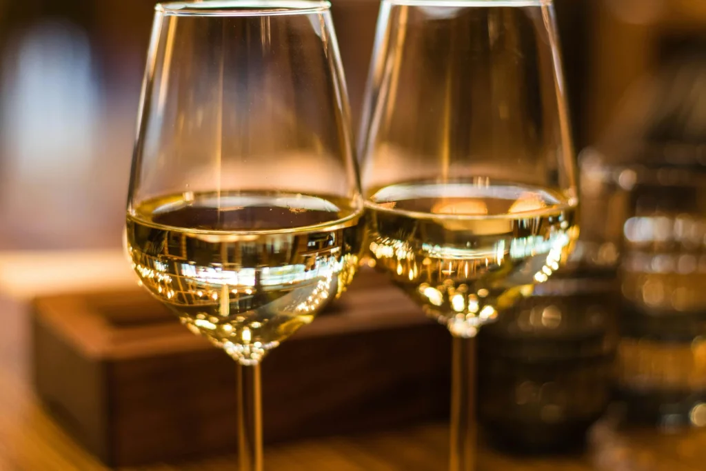 Two elegant glasses of chilled white wine catching the warm golden light at Bar Louis in Milford, PA.