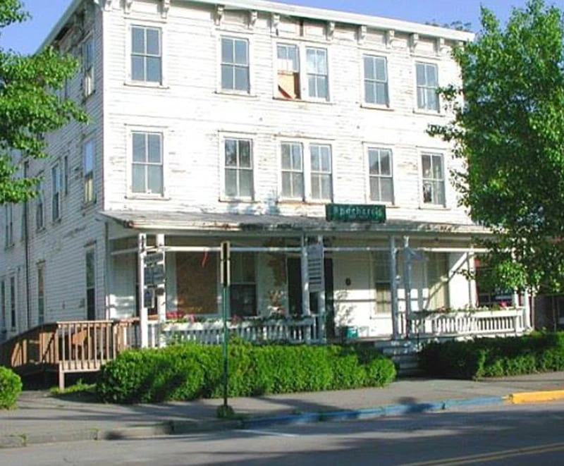 The white three-story exterior of Hotel Fauchère, a historic place to stay in the heart of Milford, PA.