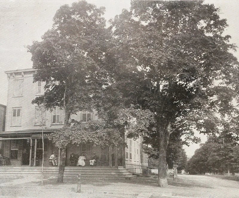 A vintage photograph of people sitting on the porch of the historic Hotel Fauchère in Milford, PA.