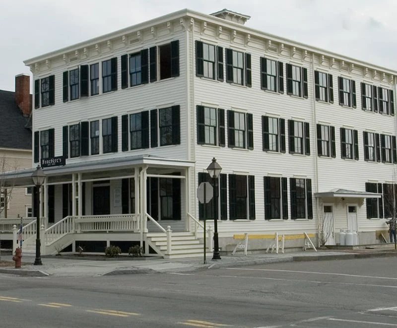The classic white exterior and black shutters of Hotel Fauchère in the historic district of Milford, PA.
