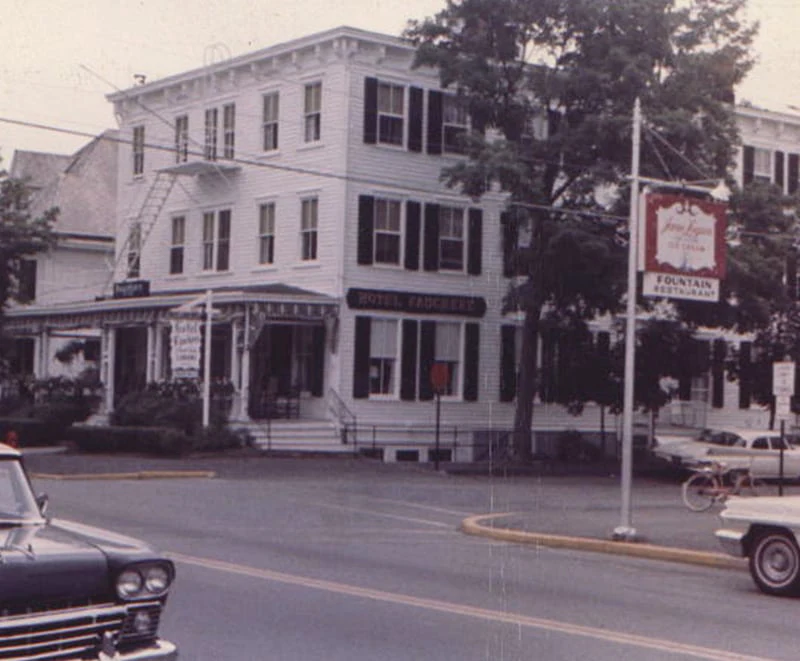 an old photo of a street corner with a car parked in front of a building